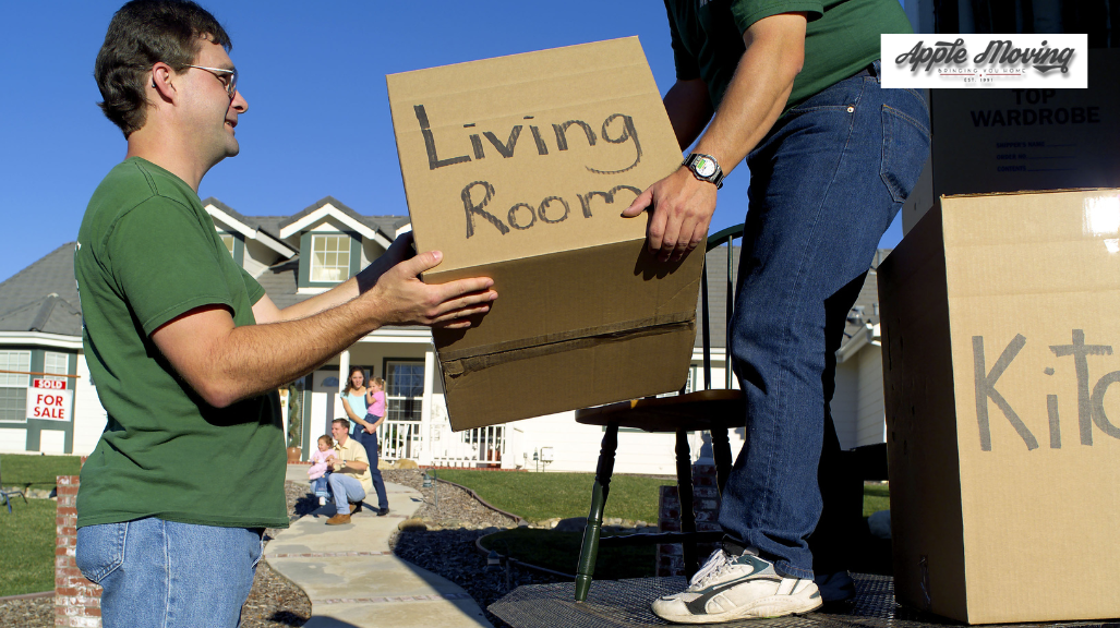 man lifting living room labeled box